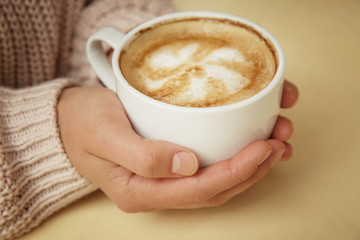 Woman holding cup of coffee, closeup