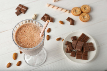 Fresh tasty chocolate cocktail and sweets on wooden background