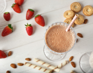 Tasty cocktail with fresh berries and sweets on wooden background