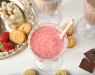 Tasty strawberry cocktail with berries and sweets on wooden background