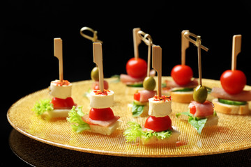 Set of delicious canapes on dark background