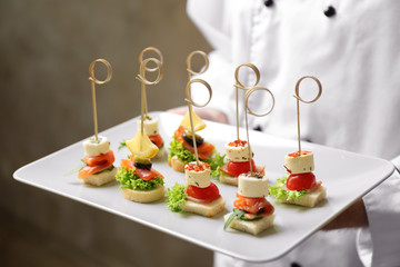Chef holding plate with assorted canapes closeup