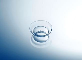 Contact lens on smooth light background, close up view. Medicine and vision concept