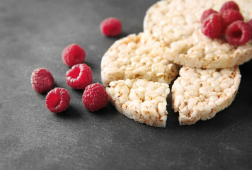 Round rice crispbreads with raspberries on table, closeup