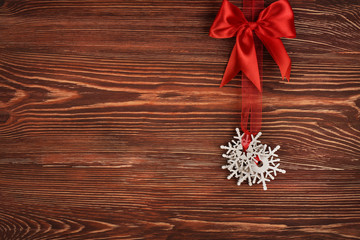 Christmas decoration hanging on ribbon against wooden background