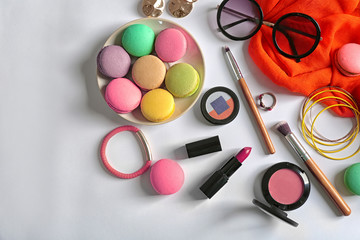 Obraz na płótnie Canvas Makeup products, accessories and macaroons on white background