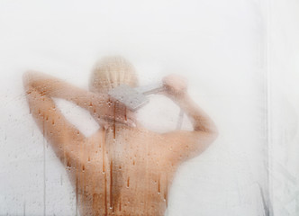 Beautiful young woman  washing body in a shower