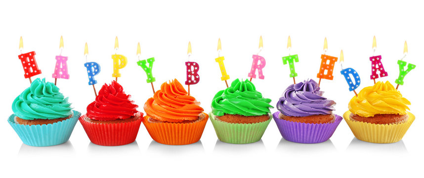 Tasty colorful cupcakes with Happy Birthday candles on white background