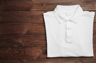 Blank white polo shirt on wooden background
