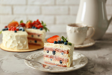 Piece of delicious cake with berries on grey table closeup