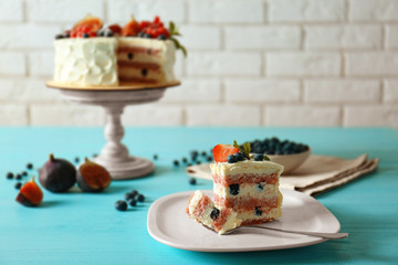 Piece of delicious cake with berries on table closeup