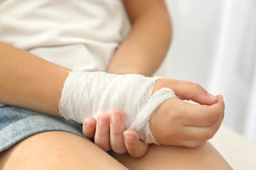 Fototapeta na wymiar Close up view of little girl's wrist with applied bandage