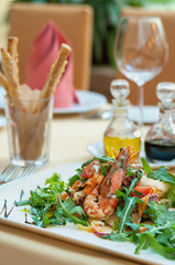 Fresh salad with seafood, fried shrimp and arugula in the restau