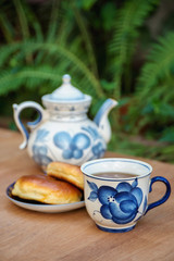 Tea set. Porcelain vintage cup and  teapot with cakes outdoors.