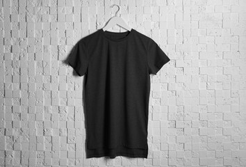 Blank black t-shirt against light textured background