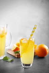 Glass of refreshing orange drink on table