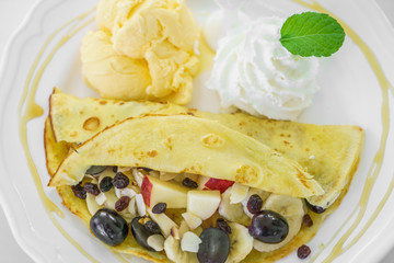 Pancake and fruit with ice cream on table
