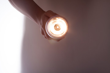 懐中電灯を手に持って照らす