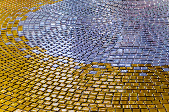 Gold and Silver color tiles on the floor of hall