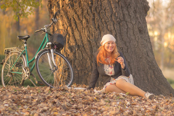 Naklejka na ściany i meble Young overweight woman, bicycle, relaxing park autumn