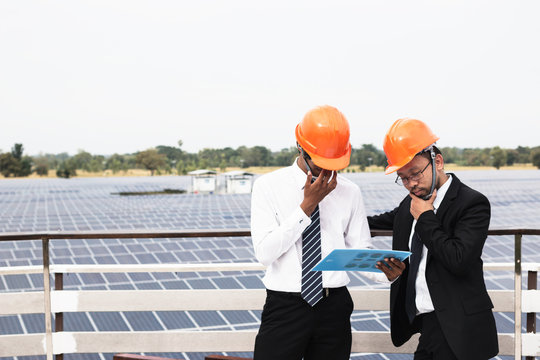 engineer working on checking and maintenance equipment at industry solar power; two engineer discussion plan to find problem of solar panel