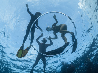 Underwater shot of the people snorkeling in the tropical sea and bubble ring ascending from the...
