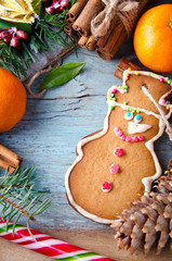 Christmas, New Year Composition with Gingerbread Man, Tangerines, Fir Tree, Cinnamon and Candy Canes. Shiny Holiday Decoration on Blue Wooden Background