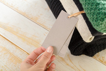 Stack of wool knitted warm sweater and white label for text