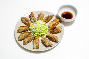 fried gyoza (dumpling) with salad and sauce isolated on white background