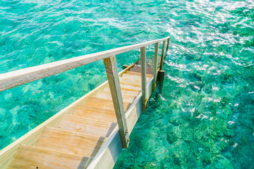Fototapeta na wymiar Wood stair into the sea of tropical Maldives island .