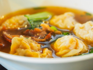 Shrimp dumplings with soup in white blow.
