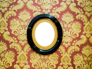 Oval wall picture frame at center on classic wallpaper with copy