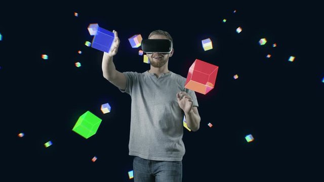 Man with VR gear glasses within interactive space touch virtual cubes