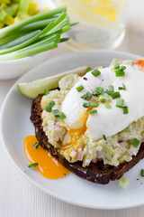 Avocado and feta smash on rye bread and poached  egg on top