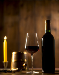 Pouring red wine into wineglass from green bottle