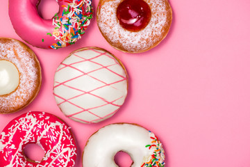 Donuts with icing on pastel pink background. Sweet donuts.