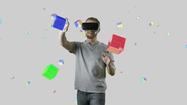 Man with VR gear glasses within interactive space touch virtual cubes