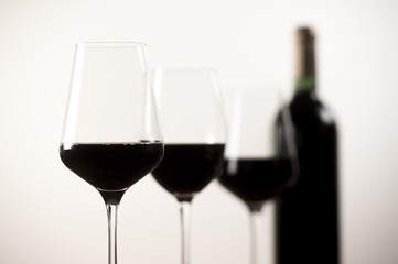 Red Wine bottle and three glass on white background