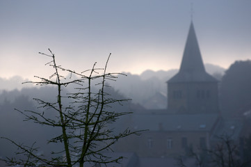Belgian landscape with church and fog 
