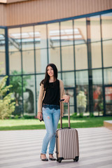 young attractive girl with a suitcase goes on the terminal