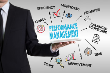 Performance Management concept. Young man holding a tablet compu