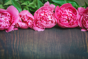 Red and pink peonies on a wooden table. Beautiful floral background.