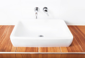 Fototapeta premium White porcelain washbasin and chrome-plated faucets.