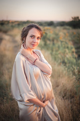 Fototapeta na wymiar Portrait of a young beautiful pregnant woman on nature.