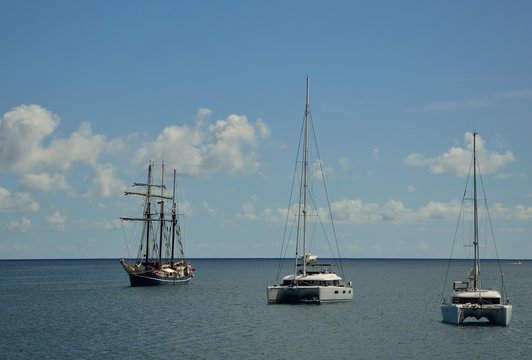 Catamarans and great sailboat anchored in the bay