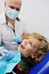 smiling child sitting in a blue chair dental