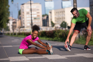 jogging couple warming up and stretching in the city