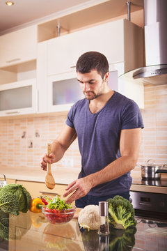 Portrait of a smiling man preparing salad
