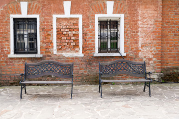 two benches on the background of an old brick wall