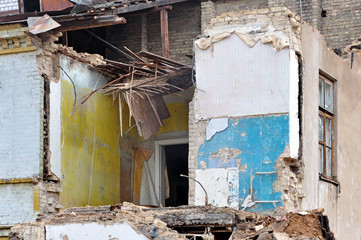 Process of demolition of a residential building. Ruined walls and hardwood floors. Theme of war,...